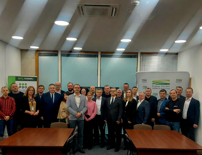 Zdjęcie grupowe zespołu PDO na tle baneru KOWRu