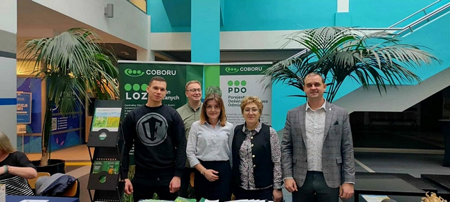 Dyrektor stacji z pracownikami na tle stoiska SDOO CIcibór