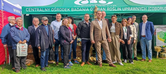 Zdjęcie grupowe na tle Stoiska COBRU